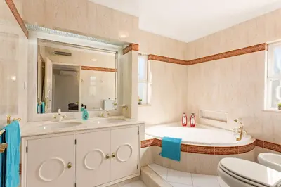 a bathroom with a sink and a tub and a toilet at Villa Casa do Mel by Villa Plus in Loulé