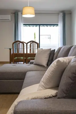 a living room with a gray couch and a table at Miral 2 - Beach front apartment with pool in Quarteira