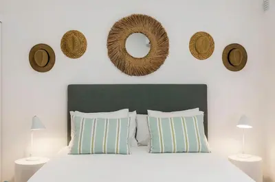 a bedroom with a bed with pillows and a mirror at RG Studio in Faro