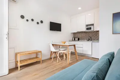 a living room with a table and a kitchen at RG Studio in Faro