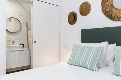 a white bedroom with a bed and a sink at RG Studio in Faro