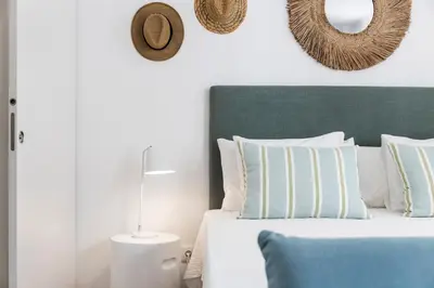 a bedroom with a bed with a green headboard and pillows at RG Studio in Faro