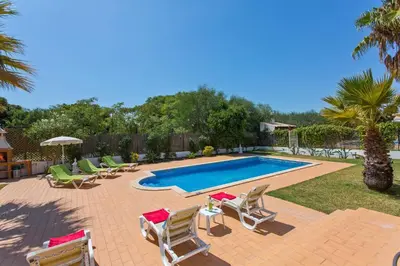 a swimming pool with lounge chairs and a swimming pool at Villa Celia by Villa Plus in Olhos de Água