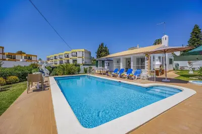 a swimming pool in front of a house at Villa Eliza by Villa Plus in Albufeira