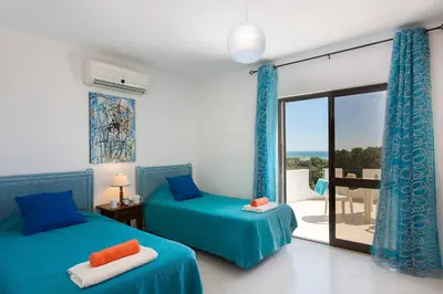 a bedroom with two beds and a balcony at Villa Gregorio by Villa Plus in Galé