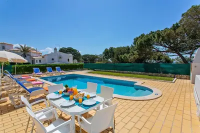 a patio with a table and chairs and a pool at Villa Gregorio by Villa Plus in Galé