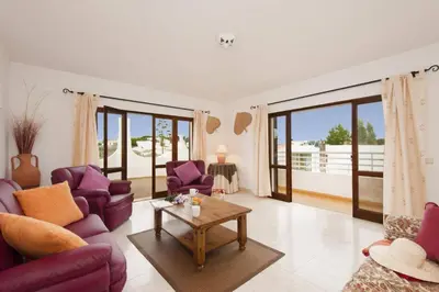 a living room with purple chairs and a table at Villa Medeira by Villa Plus in Albufeira