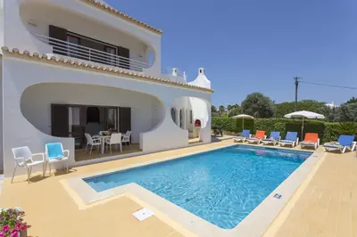 a villa with a swimming pool in front of a house at Villa Medeira by Villa Plus in Albufeira