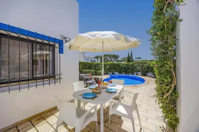 a patio with a table and chairs and a pool at Villa Casa Michelle by Villa Plus in Almancil