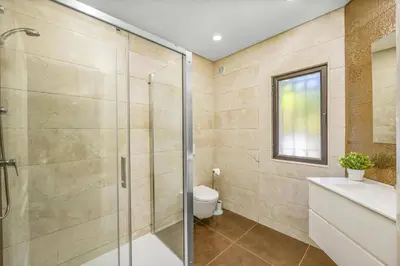 a bathroom with a glass shower and a toilet at Villa Casa Michelle by Villa Plus in Almancil