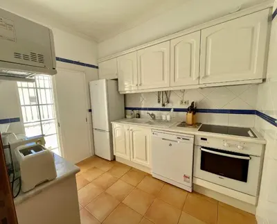 a kitchen with white cabinets and white appliances at Moradia da Encosta- Vilamoura in Vilamoura