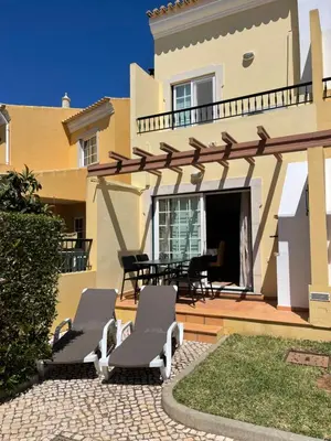 a patio with two lounge chairs and a house at Moradia da Encosta- Vilamoura in Vilamoura