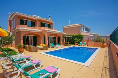 a villa with a swimming pool in front of a house at Villa Bali by Villa Plus in Albufeira