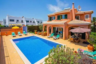 a villa with a swimming pool in front of a house at Villa Bali by Villa Plus in Albufeira