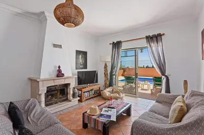 a living room with a couch and a fireplace at Villa Bali by Villa Plus in Albufeira
