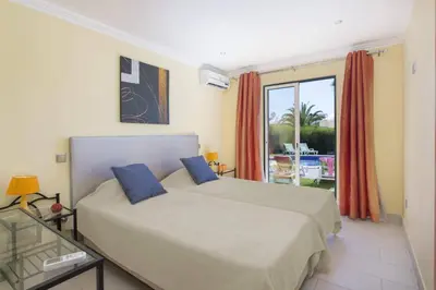 a bedroom with a bed and a large window at Villa Bolina by Villa Plus in Albufeira
