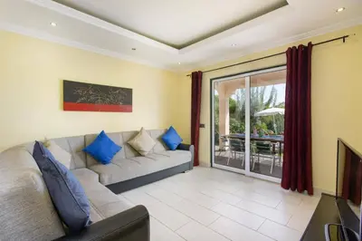 a living room with a couch and a sliding glass door at Villa Bolina by Villa Plus in Albufeira