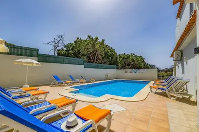 a swimming pool with lounge chairs and a swimming pool at Villa Canas by Villa Plus in Vale do Lobo