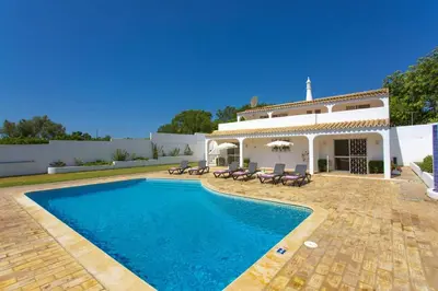 a villa with a swimming pool in front of a house at Villa Citrinos by Villa Plus in Almancil