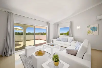 a living room with white furniture and a large window at Villa Citrinos by Villa Plus in Almancil