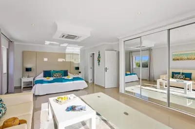 a bedroom with a bed and a living room at Villa Pianda by Villa Plus in Almancil
