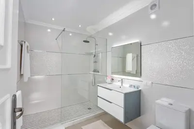 a white bathroom with a shower and a sink at Villa Pianda by Villa Plus in Almancil