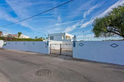 a white fence in front of a white house at Villa Pianda by Villa Plus in Almancil