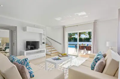 a living room with white furniture and a view of the ocean at Villa Pianda by Villa Plus in Almancil