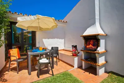 a patio with a table and an outdoor oven at Villa Sueste by Villa Plus in Albufeira