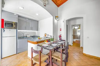 a kitchen with a table and some chairs in it at Villa Sueste by Villa Plus in Albufeira