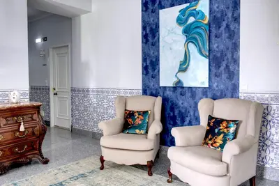 two chairs and a dresser in a room with blue walls at Palacete da Baixa by MY CHOICE in Faro