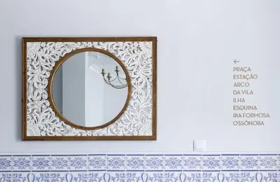 a mirror with a wooden frame on a wall at Palacete da Baixa by MY CHOICE in Faro
