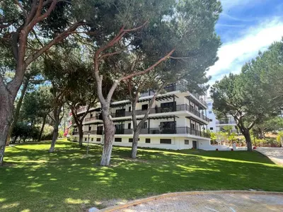 an apartment building with trees in front of it at Falesia Beach Apartment in Albufeira