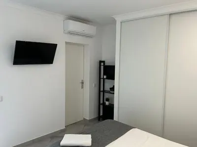 a bedroom with a bed and a tv on a wall at Old Town House in Loulé