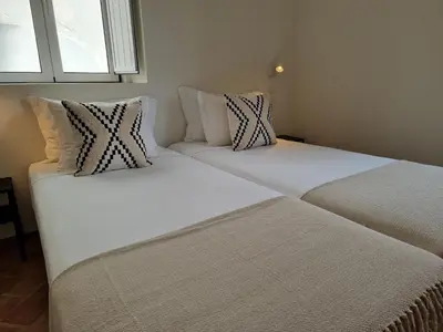 two beds sitting next to each other in a room at Casa Algarbe in Faro