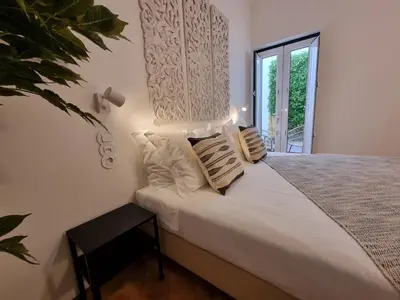 a bedroom with a bed with white sheets and a window at Casa Algarbe in Faro