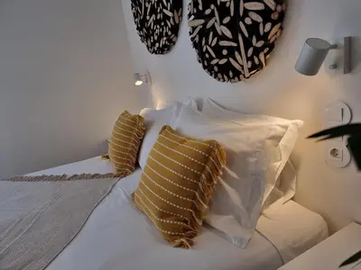 a white bed with two pillows on top of it at Casa Algarbe in Faro