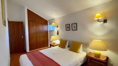 a bedroom with a bed with yellow pillows and two lamps at Sol by Check-in Portugal in Vilamoura