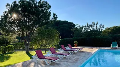 a row of lounge chairs next to a swimming pool at Sol by Check-in Portugal in Vilamoura