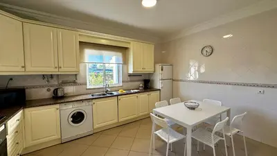 a kitchen with a table and a white table and chairs at Ellegance by Check-in Portugal in Vilamoura