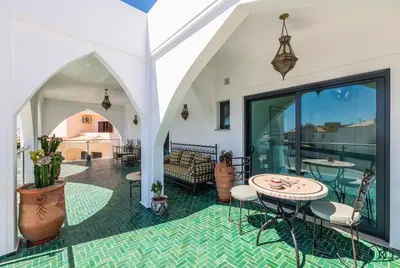 a room with a patio with a table and chairs at Riad Matias Galé - Luxury Villa with private pool, AC, free wifi, 5 min from the beach in Guia