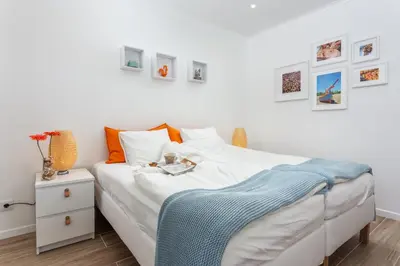 a bedroom with a white bed with a blue blanket on it at Modern ocean view apt 2 min walk to beach in Quarteira