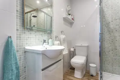 a white bathroom with a sink and a toilet at Modern ocean view apt 2 min walk to beach in Quarteira