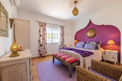 a bedroom with a large bed and a purple wall at Villa Oasis Galé - Luxury Villa with private pool, AC, free wifi, 5 min from the beach in Albufeira