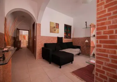 a living room with a black couch and a brick wall at ALGARVE TYPICAL DOWNTOWN HOUSE in Faro