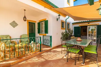 a house with a balcony with a table and chairs at Riad Serpa Galé - Luxury, private pool, AC, wifi, 5 min from the beach in Guia