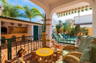a patio with a table and chairs on a balcony at Riad Serpa Galé - Luxury, private pool, AC, wifi, 5 min from the beach in Guia