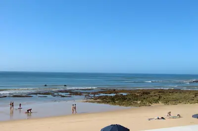 a group of people on a beach with the ocean at Ocean and pool in Olhos de Água