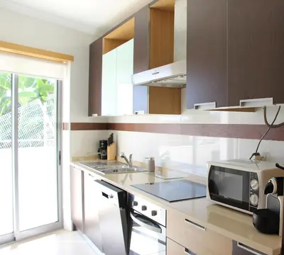 a kitchen with a microwave and a sink at Ocean and pool in Olhos de Água