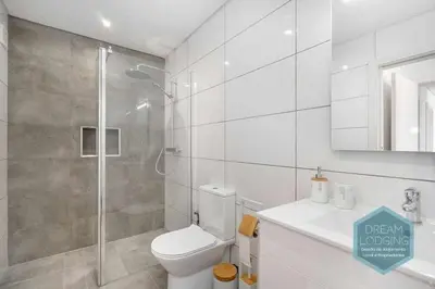 a white bathroom with a toilet and a shower at Casa do Alto - Dream Lodging in Albufeira